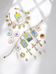 Gedetailleerde foto van gouden tarot hangers en RVS sieraden met artistieke schaduw