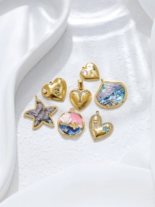 Détail de pendentifs cœur et étoile de mer en plaqué or 18K avec incrustations de nacre