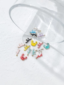 Detailed close-up of colorful enamel crab and coral charms spilling from a glass jar