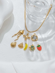 Detail of 18K gold plated stainless steel pendants including jellyfish and fruit charms
