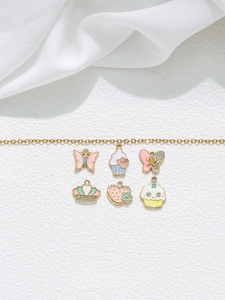 Détail du kit de charms DIY avec papillon, couronne et cupcake sur chaîne dorée