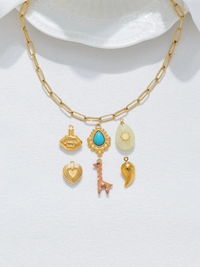 Detail of vintage gold chain with perfume bottle, giraffe and heart shaped pendants