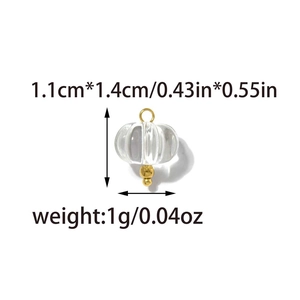 Detailed view of clear pumpkin charm with gold accents and size measurements for DIY jewelry