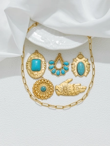 Vue détaillée de breloques vintage dorées avec turquoise, main de Hamsa et motifs