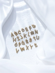 Detaillierte Ansicht von 26 vergoldeten Buchstaben-Anhängern mit funkelnden Kristallen