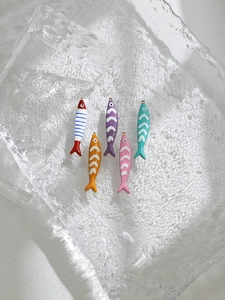 Dettaglio di cinque ciondoli a forma di pesce in smalto colorato per gioielli fai-da-te