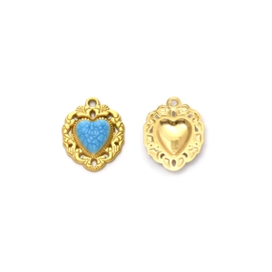 Pendentif cœur vintage doré avec incrustation bleue et bordure filigranée sur fond blanc