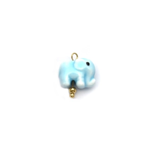 Détail d'un pendentif éléphant en céramique bleu clair avec anneau doré et billes décoratives