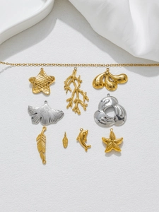 Detaillierte Makroansicht von Edelstahl-Anhängern in Gold und Silber mit Meeresmotiven