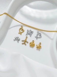 Detail of stainless steel charms featuring heart, plane, and rose shapes for DIY jewelry