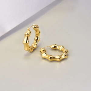Detailansicht der goldenen Creolen mit realistischer Bambustextur und metallischem Glanzfinish