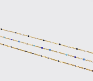 Vista macro detallada del collar de cadena dorada con cuentas de esmalte azul