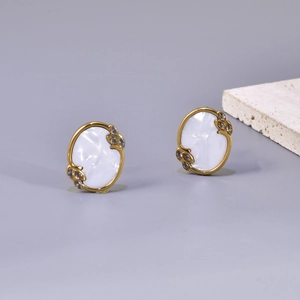 Detail of vintage oval 18K gold earrings with white shell inlay and champagne crystals
