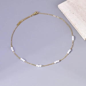 Detail van een minimalistische gouden ketting met witte parels en S925 zilveren merk