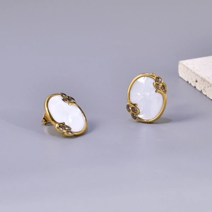 Gold-plated oval stud earrings with white shell inlay and leaf-shaped crystal details