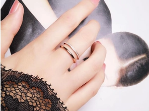 Detail eines zweischichtigen Roségoldrings mit Micro-Pave-Kristallen an der Hand
