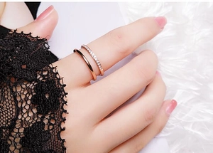 Nahaufnahme eines zweischichtigen Roségoldrings mit Pavé-Diamanten an der Hand des Models