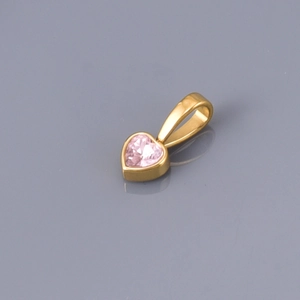 Detail showing a golden heart pendant with a faceted pink zircon gemstone inlay