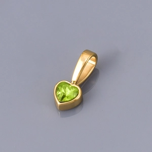 Macro detail of heart-shaped olive green zircon pendant with polished gold plating
