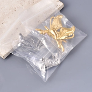 Dettaglio degli orecchini a farfalla in acciaio inossidabile color oro e argento