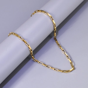 Détail d'un collier chaîne à trombones plaqué or 18 carats sur un support d'exposition
