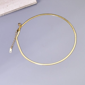Close-up of gold herringbone chain with K18 engraving and lobster clasp on purple background