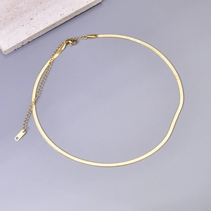 Detailed close-up of golden flat snake chain with K18 engraving and lobster clasp