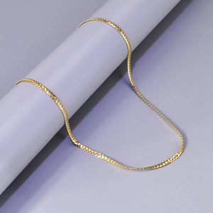 Vue macro d'un collier chaîne serpent dorée de 1,5 mm avec texture polie brillante