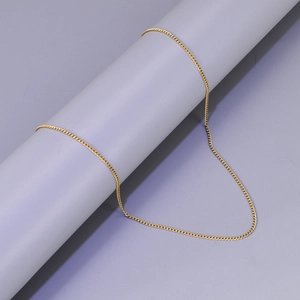 Detailansicht einer 18K vergoldeten Panzerkette an einem minimalistischen Displayständer