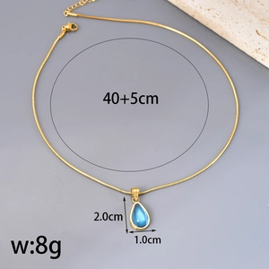 Gouden slangenketting met blauwe druppelvormige kristallen hanger op stenen achtergrond