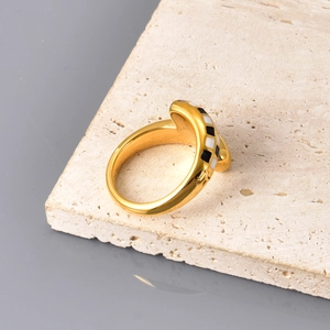 Detail der 18K vergoldeten Ringe mit schwarz-weißem Schachbrett-Emaille-Design