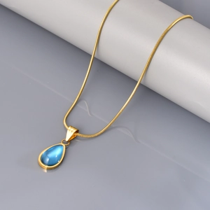 Detail van de blauwe waterdruppel hanger aan een goudkleurige slangenketting