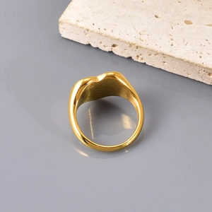 Detailaufnahme des 18K vergoldeten Herzrings mit Politur auf einer Steinplatte