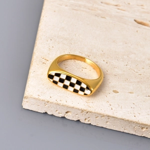 Nahaufnahme des 18K vergoldeten Rings mit schwarz-weißem Schachbrett-Emaille-Muster
