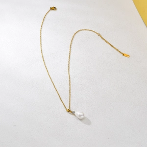 Collana dorata con perla a goccia, zircone e targhetta K18 su sfondo bianco strutturato