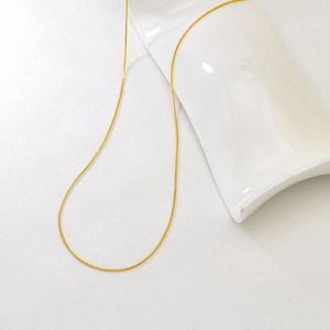 Detail of adjustable gold snake chain necklace with smooth polished metallic finish