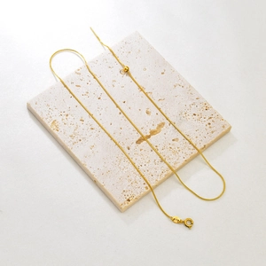 Close-up of adjustable golden snake chain necklace with round slider on stone