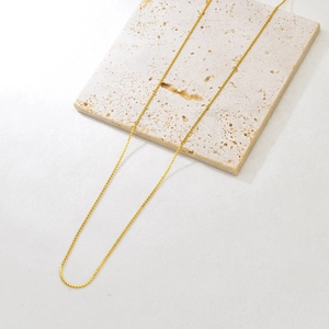 Close-up of adjustable golden stainless steel necklace with fine twisted texture on stone