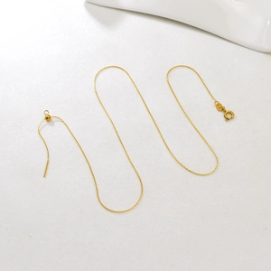 Detail of adjustable gold stainless steel chain necklace with slider bead and pin