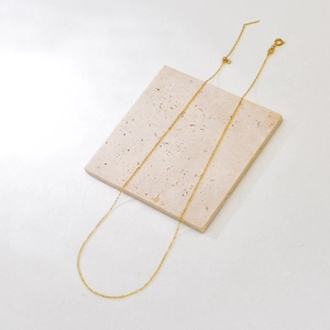 Detail of adjustable gold-plated stainless steel chain with round spring clasp and slide bead