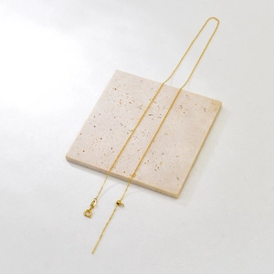 Adjustable golden stainless steel chain with sliding bead and needle end detail