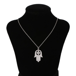 Hamsa hand hanger ketting met bloemmotief en fonkelende kristallen op een zwarte buste