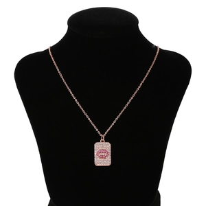 Détail du pendentif plaque or rose avec motif lèvres en zircon rose sur buste noir