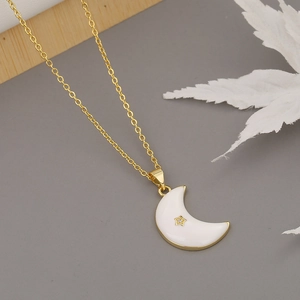 Detalle del colgante de luna dorada con esmalte blanco y pequeña estrella de circón