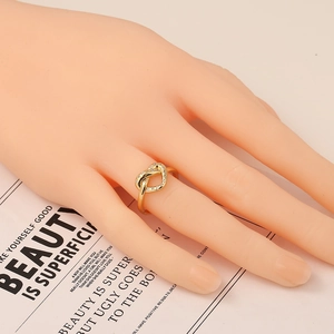 Anello a cuore dorato con zirconi brillanti, indossato al dito per dimostrazione