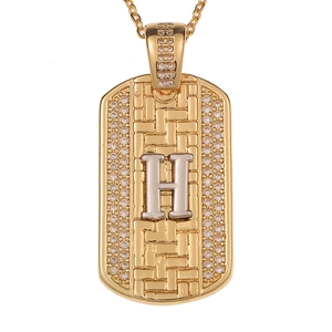 Detalle del colgante hip hop dorado con letra H plateada y cristales incrustados