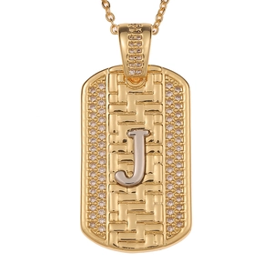 Detalle macro del colgante dog tag dorado con letra J y bordes de diamantes de imitación
