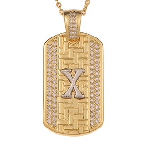 Primer plano del collar de chapa dorada con textura tejida y letra X engastada con diamantes