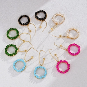 Handcrafted circular crystal beaded drop earrings in five colors on a white stone background