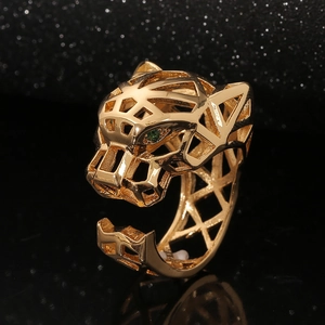 Macro shot of gold leopard ring featuring green gemstone eyes and geometric cutout design